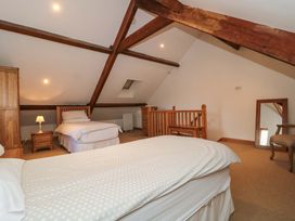 A bedroom with two beds and furniture at Riverside Barn in Gilwern near Crickhowell and Abergavenny