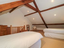 A bedroom with two beds and a dresser at Riverside Barn in Gilwern near Crickhowell and Abergavenny