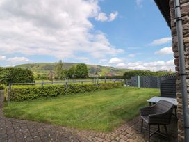 A garden with grass and seating area at Riverside Barn in Gilwern near Crickhowell and Abergavenny