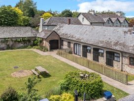 An outdoor area with a barn and garden at Keepers Cottage in Winterborne Stickland