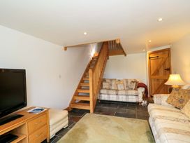 A living room with a television and sofa at Longside in Gilwern