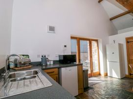 A kitchen with a sink, refrigerator, and appliances at Longside in Gilwern