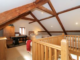 A bedroom with wooden beams and furniture at Longside in Gilwern