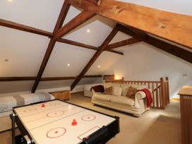 A game room with a sofa and an air hockey table at Longside in Gilwern