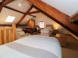 A bedroom with two beds, a table, and a chair at Longside in Gilwern
