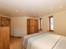 A bedroom with a bed and wardrobe at Longside in Gilwern