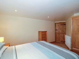 A bedroom with a bed and dresser at Longside in Gilwern