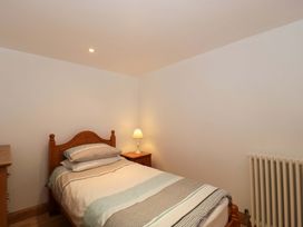 A bedroom with a bed and lamp at Longside in Gilwern
