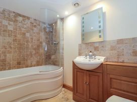 A bathroom with a bathtub and sink at Longside in Gilwern