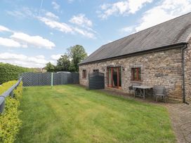 A garden area with a table and chairs at Longside in Gilwern