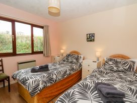 A bedroom with two single beds lamps and a window at Bryn yr Haf in Llanfair Clydogau near Lampeter
