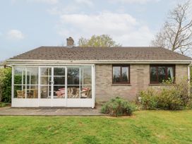 A single story brick house with a glass enclosed porch and lawn at Bryn yr Haf in Llanfair Clydogau near Lampeter