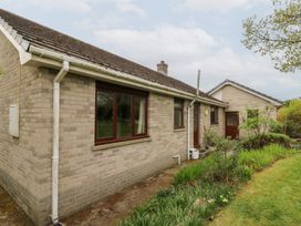 A brick house with windows and doors surrounded by a garden and grass at Bryn yr Haf in Llanfair Clydogau near Lampeter