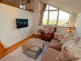 A living room with a television and sofa at Hawkrigg Cottage in Kirkby Lonsdale