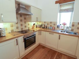 A kitchen with an oven and sink at Hawkrigg Cottage Kirkby Lonsdale