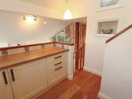 A kitchen area with a counter and stairs at Hawkrigg Cottage in Kirkby Lonsdale