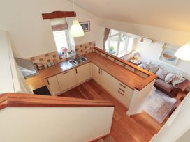 A kitchen with a counter, sink, and sofa at Hawkrigg Cottage in Kirkby Lonsdale