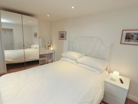 A bedroom with a bed and nightstand at Hawkrigg Cottage in Kirkby Lonsdale