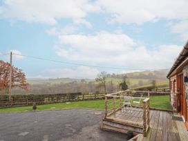 A deck area with table and chairs at Rhianwen, Plas Moelfre Hall Barns Llanrhaeadr-ym-Mochnant