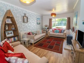 A living room with a sofa and bookshelves at Salty Puffin in Benllech