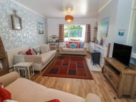 A living room with a sofa and television at Salty Puffin in Benllech