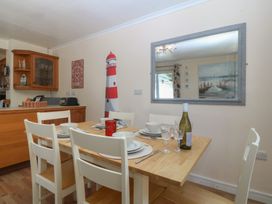 A dining room with a table and chairs at Salty Puffin in Benllech