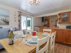 A dining room with a table set for meals at Salty Puffin Benllech