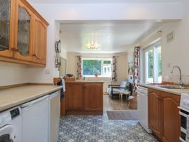 A kitchen with appliances and furniture at Salty Puffin in Benllech