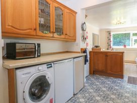 A kitchen with appliances and cabinetry at Salty Puffin in Benllech