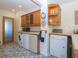 A kitchen with appliances and a storage cabinet at Salty Puffin in Benllech