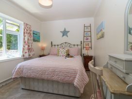A bedroom with a bed and bedside table at Salty Puffin in Benllech