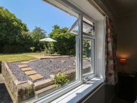 A view from a window showing a garden with a table and chairs at Salty Puffin in Benllech