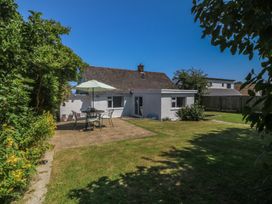 A garden with a table and chairs at Salty Puffin Benllech