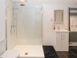A bathroom with a walk in shower toilet sink mirror and towel rack at Dovetail Cottage in Llangollen