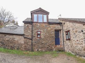 Exterior view of a stone cottage with a blue door and multiple windows at Dovetail Cottage in Llangollen