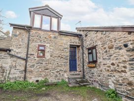 An entrance with stone walls and steps at Dovetail Cottage in Llangollen