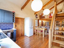 A kitchen with a dining table and chairs at Dovetail Cottage in Llangollen