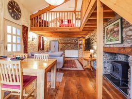 A living room with a dining table and sofa at Dovetail Cottage in Llangollen