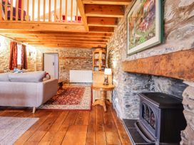 A living room with a sofa and a fireplace at Dovetail Cottage Llangollen