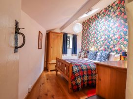 A bedroom with a bed and wardrobe at Dovetail Cottage Llangollen