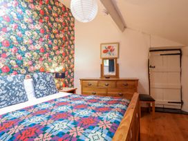 A bedroom with a bed and chest of drawers at Dovetail Cottage in Llangollen
