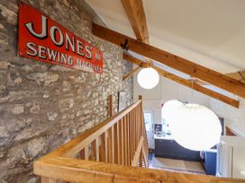 A hallway with a sewing machine sign and pendant lights at Dovetail Cottage in Llangollen