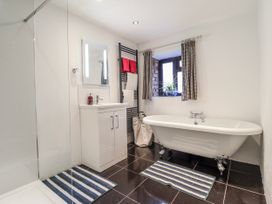 A bathroom with a bathtub and vanity at Dovetail Cottage in Llangollen