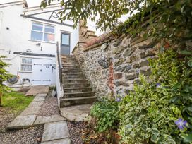 A garden with stairs leading to a door at Dovetail Cottage in Llangollen