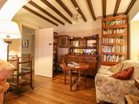 A living room with a sofa and bookshelf at Murmur Y Don in Harlech