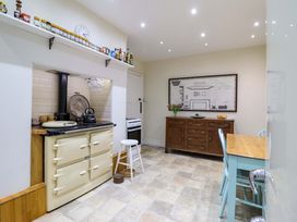 A kitchen with cabinets and table at Murmur Y Don in Harlech