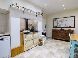 A kitchen featuring an oven, stove, table and chairs at Murmur Y Don in Harlech