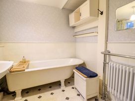 A bathroom with a bathtub and towel at Murmur Y Don in Harlech
