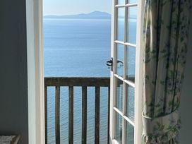 A balcony view overlooking water and mountains at Murmur Y Don in Harlech