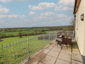 An outdoor area with chairs and a table overlooking fields at Bwthyn-y-Rhiw in Penybanc near Llandeilo